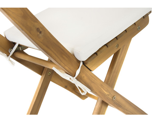 Detailansicht eines Holzstuhls mit weißem Sitzkissen