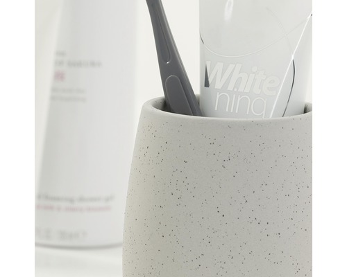 Zahnputzbecher mit Zahnbürste und Zahnpasta