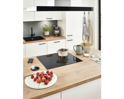 Moderne Küche mit Induktionskochfeld, Spüle, Armatur und frischem Obst auf der Arbeitsfläche