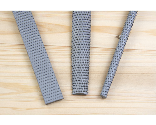 Drei Holzraspeln auf Holzhintergrund