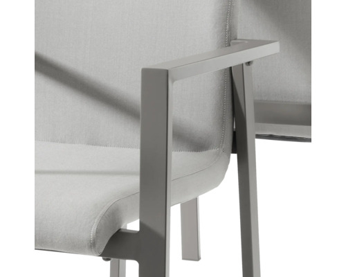 Detailansicht eines Armlehnstuhls mit Textilsitzfläche und Metallgestell