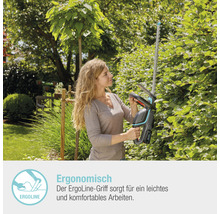 Frau schneidet Hecke mit einer Akku-Heckenschere im Garten
