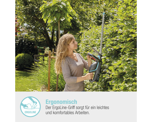 Frau schneidet Hecke mit einer Akku-Heckenschere im Garten