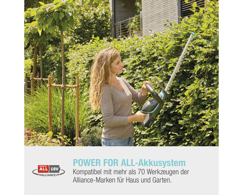 Frau schneidet Hecke mit einer Akku-Heckenschere im Garten