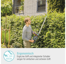 Mann schneidet Hecke mit einer Heckenschere im Garten.