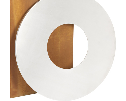 Dekorationsobjekt mit einem silberfarbenen Ring auf einer Metallplatte