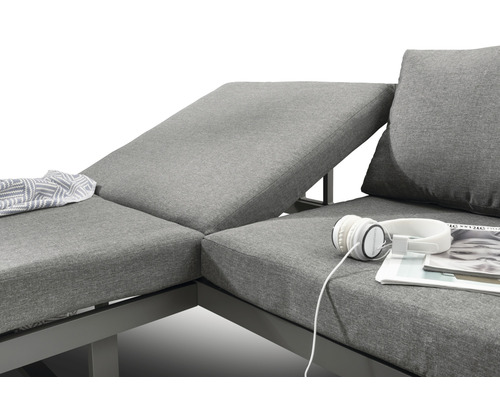 Detailansicht einer grauen Gartenlounge mit Kissen, Decke, Kopfhörern und Zeitschrift