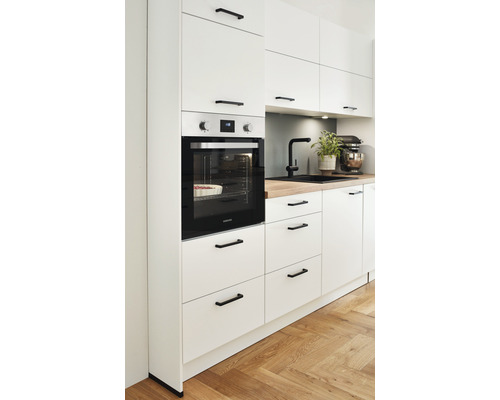 Moderne Küche mit weißen Schränken, schwarzem Ofen und Holzarbeitsplatte.