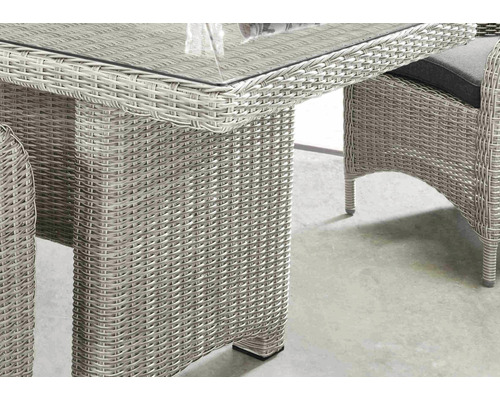 Detailansicht eines Gartentisches mit geflochtener Oberfläche und Glasplatte.