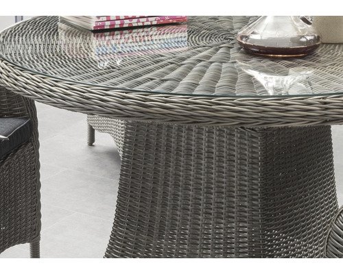 Detailansicht eines Gartentisches mit Glasplatte und Rattanstruktur