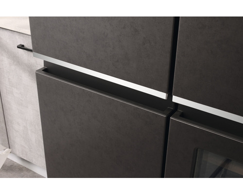 Detailaufnahme eines Küchenschranks mit matter Oberfläche und silberfarbenen Griffleisten