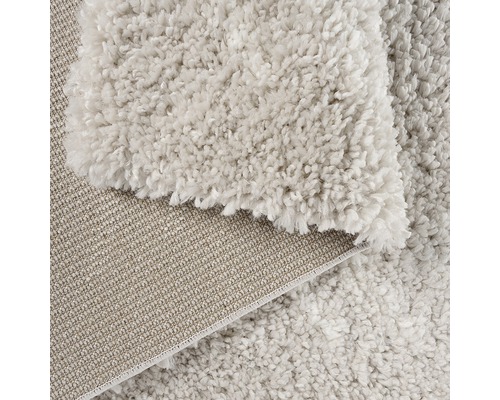 Detailansicht eines beigen Teppichs mit hochflorigem Flor