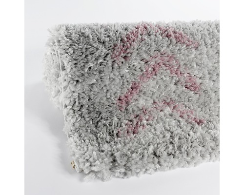 Grauer Teppich mit Muster aufgerollt