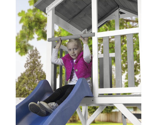 Mädchen auf einer Rutsche an einem Spielturm im Garten