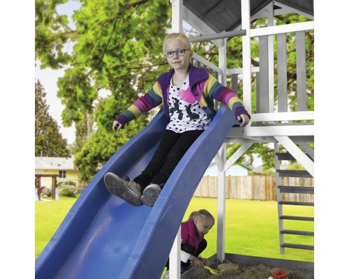 Mädchen rutscht auf einer blauen Rutsche eines Spielturms