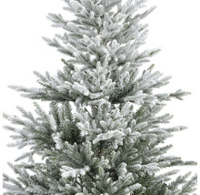 Detailaufnahme eines künstlichen Weihnachtsbaums mit Schnee bedeckt.