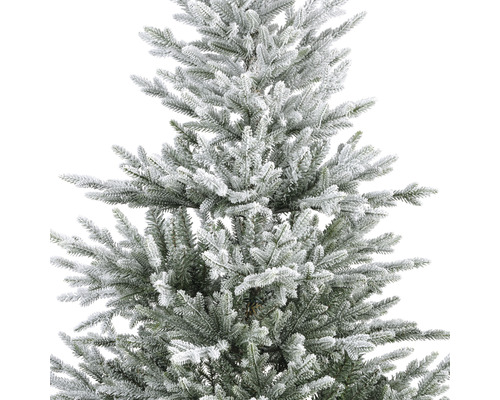 Detailaufnahme eines künstlichen Weihnachtsbaums mit Schnee bedeckt.