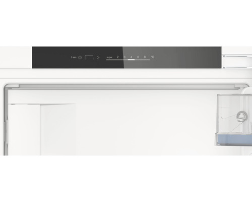 Innenraum eines Kühlschranks mit Temperaturregler und Wasserbehälter