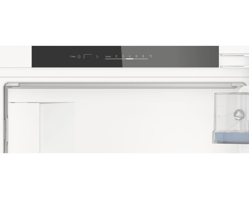 Innenansicht eines Kühlschranks mit Temperaturregler und Wasserbehälter