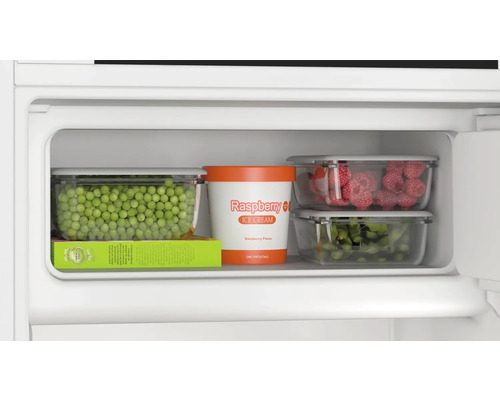 Gefrierfach mit Erbsen, Himbeereis, Himbeeren und grünen Bohnen in Aufbewahrungsbehältern