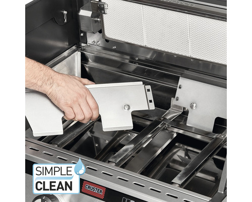 Innenansicht eines Gasgrills mit einer Person, die eine Edelstahlkomponente einsetzt, für einfache Reinigung.