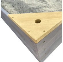Detailansicht einer dreieckigen Sandkiste aus Holz mit Bohrung