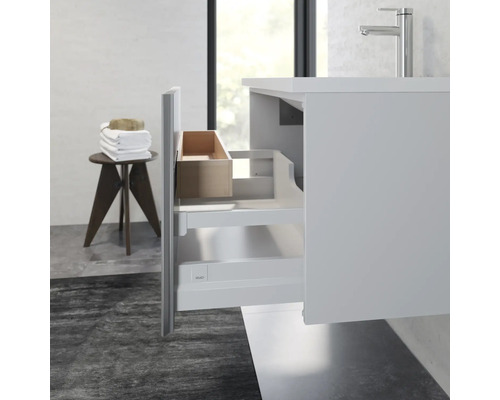 Badezimmer mit Unterschrank, Waschbecken und geöffneter Schublade für Badutensilien