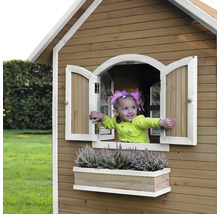 Mädchen im Holzspielhaus mit Fenster und Blumenkasten