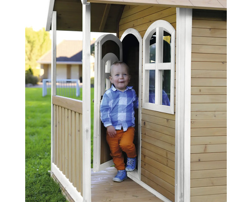 Kind in einem Holzspielhaus im Garten