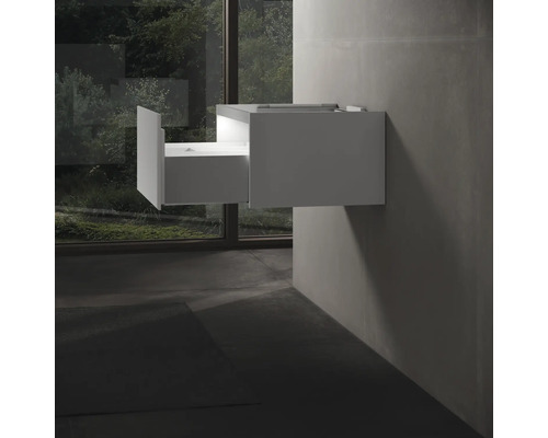 Weißer Waschtischunterschrank mit offener Schublade an der Wand montiert