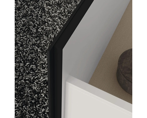 Detailaufnahme einer Badezimmerecke mit Teppich, Waschbeckenunterschrank und Ablage