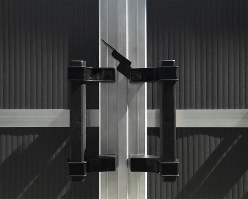 Detailansicht einer Schiebetür mit schwarzem Griff und silberfarbenem Rahmen.