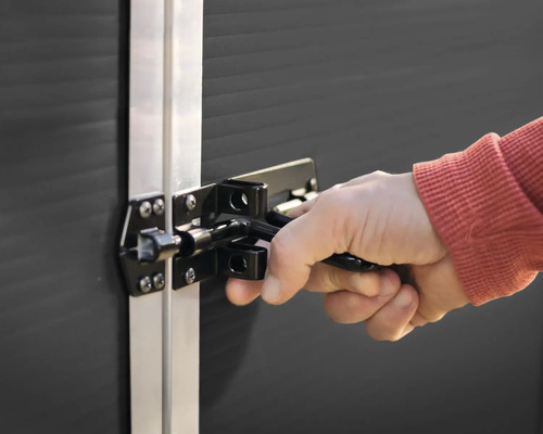 Hand betätigt ein Türschloss an einer Tür