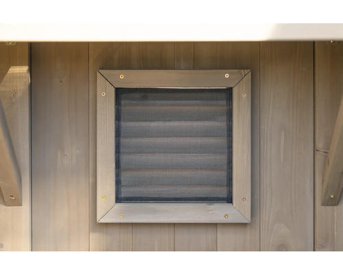 Detailansicht eines hölzernen Gartenhauses mit Fenstergitter zur Belüftung