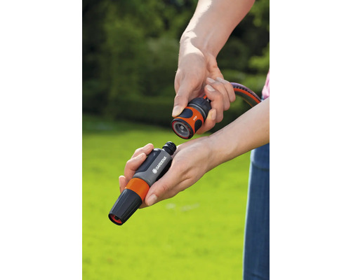 Hände verbinden Gardena Schlauchstück mit Wasserstopp