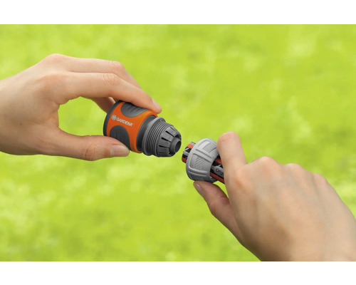 Zwei Hände verbinden einen Gardena Schlauchverbinder.