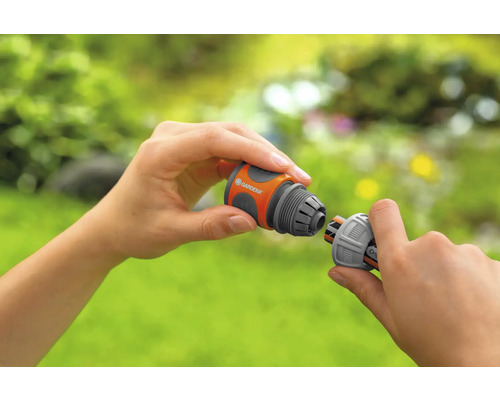 Zwei Hände verbinden zwei Gardena Schlauchverbinder.