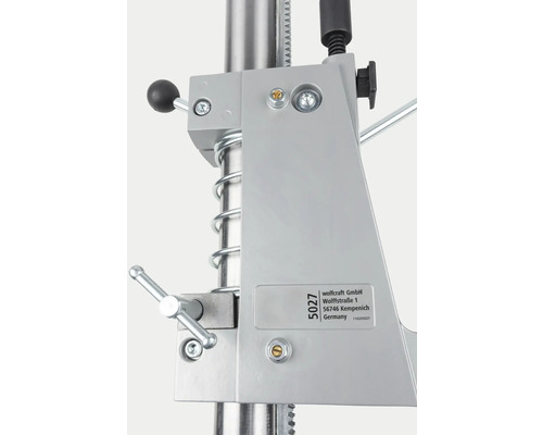 Detailansicht einer Bohrmaschine mit Halterung und Bedienelementen.