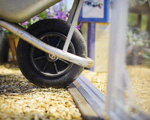 Detailaufnahme eines Schubkarrenrads auf einem Untergrund