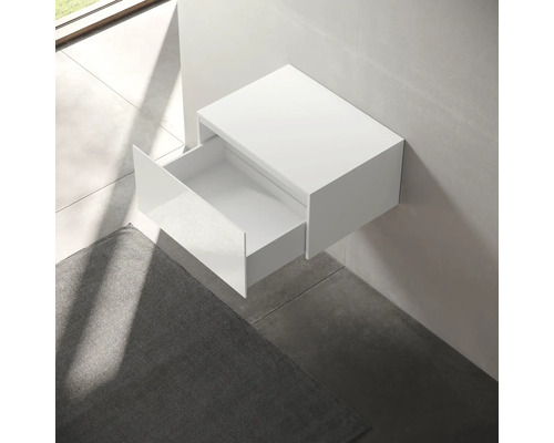 Weißer Waschbeckenunterschrank mit offener Schublade an der Wand montiert