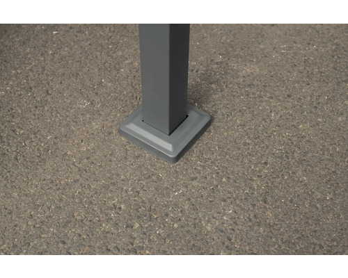 Detailansicht eines Pfostens mit quadratischer Fußplatte auf Asphalt