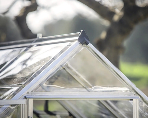 Nahaufnahme eines Gewächshauses mit Metallrahmen und transparenter Verglasung.
