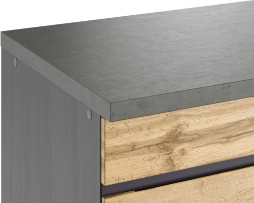 Detailansicht eines Möbels mit grauer Arbeitsplatte und Schubladen in Holzoptik