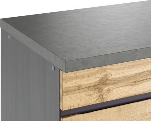 Detailaufnahme eines Möbels mit grauer Arbeitsplatte und Holzschubladen