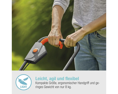 Nahaufnahme einer Person, die einen Rasenmäher mit grauem Griff und orangefarbenen Akzenten bedient.