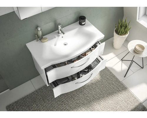 Badezimmer mit Waschbeckenunterschrank, offenstehenden Schubladen und Badteppich