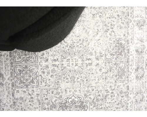 Teppich mit Ornamentmuster unter einem Möbelstück