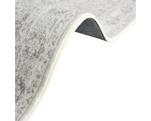 Detailansicht eines gemusterten Teppichs mit gekräuselter Ecke