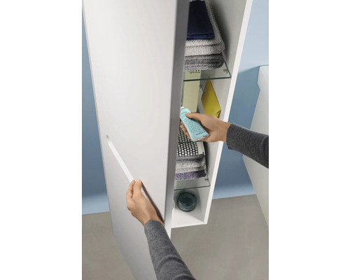 Person öffnet einen Badezimmerschrank mit Regalböden zur Aufbewahrung von Handtüchern und Badutensilien.