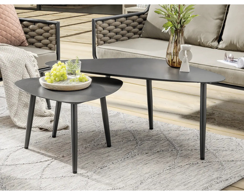 Zwei graue Couchtische mit Dreiecksform auf einem grauen Teppich im Freien.